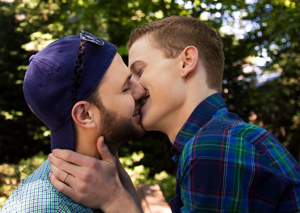 two men smiling and kissing