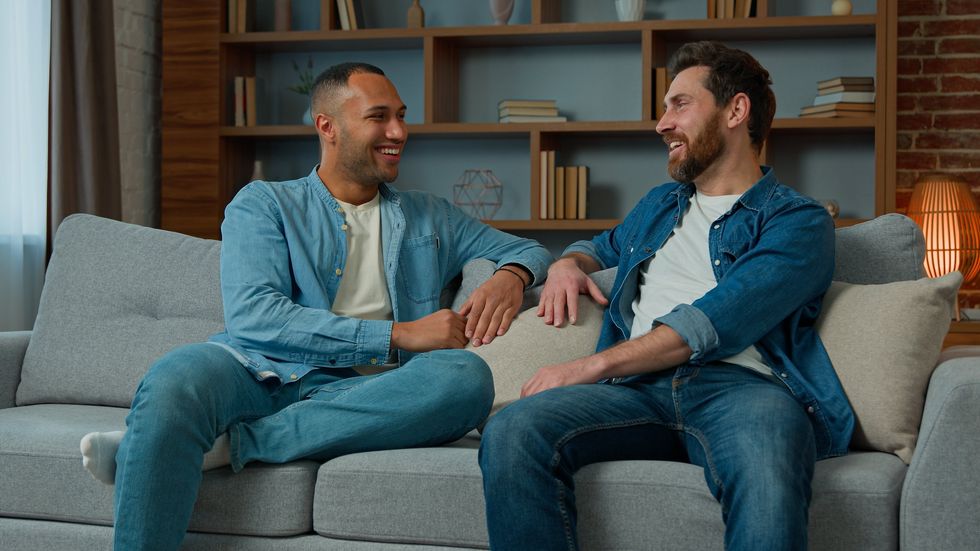 two men talking on a couch