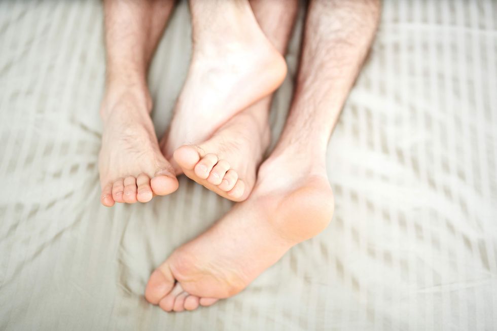 Two people's feet in bed