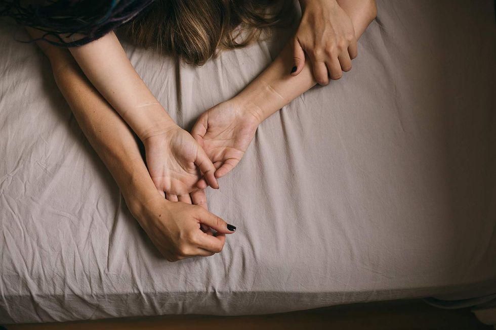 Two set of womens hands in bed