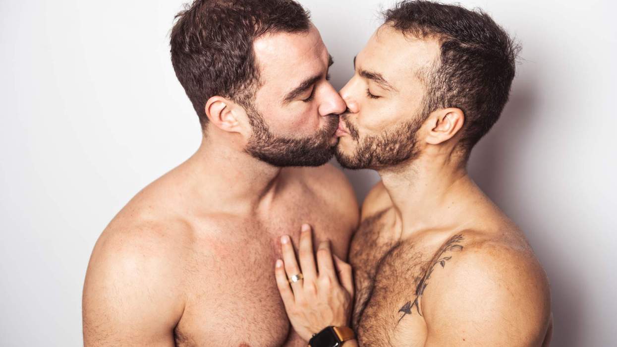 Two shirtless gay men kissing