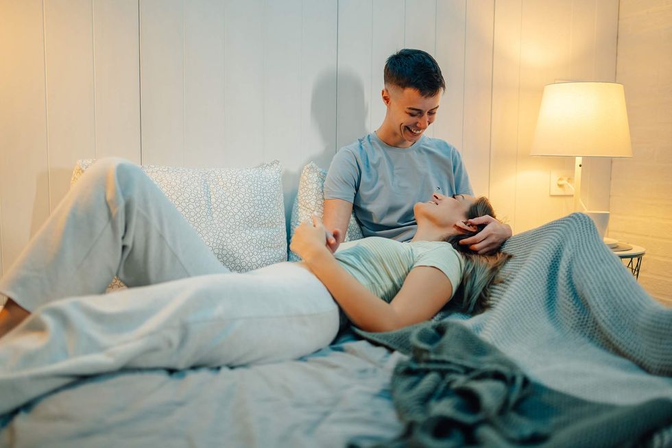 two woman laying in bed