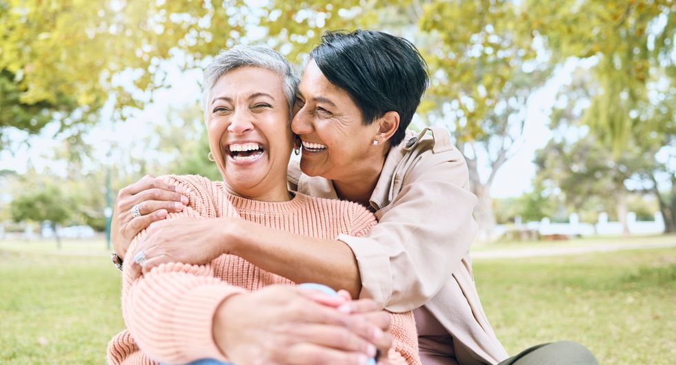 two women cuddling and smiling