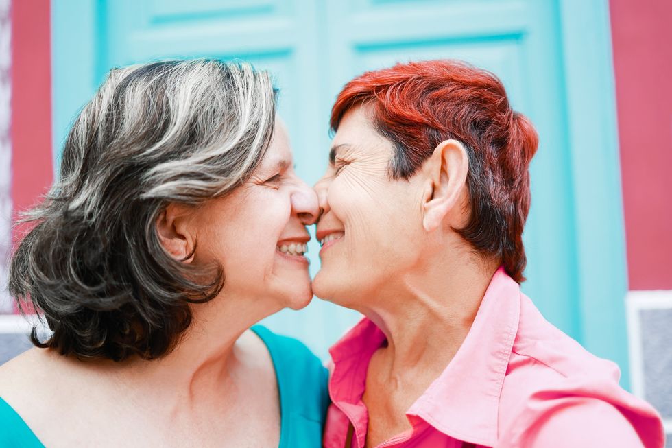 two women kissing and smiling