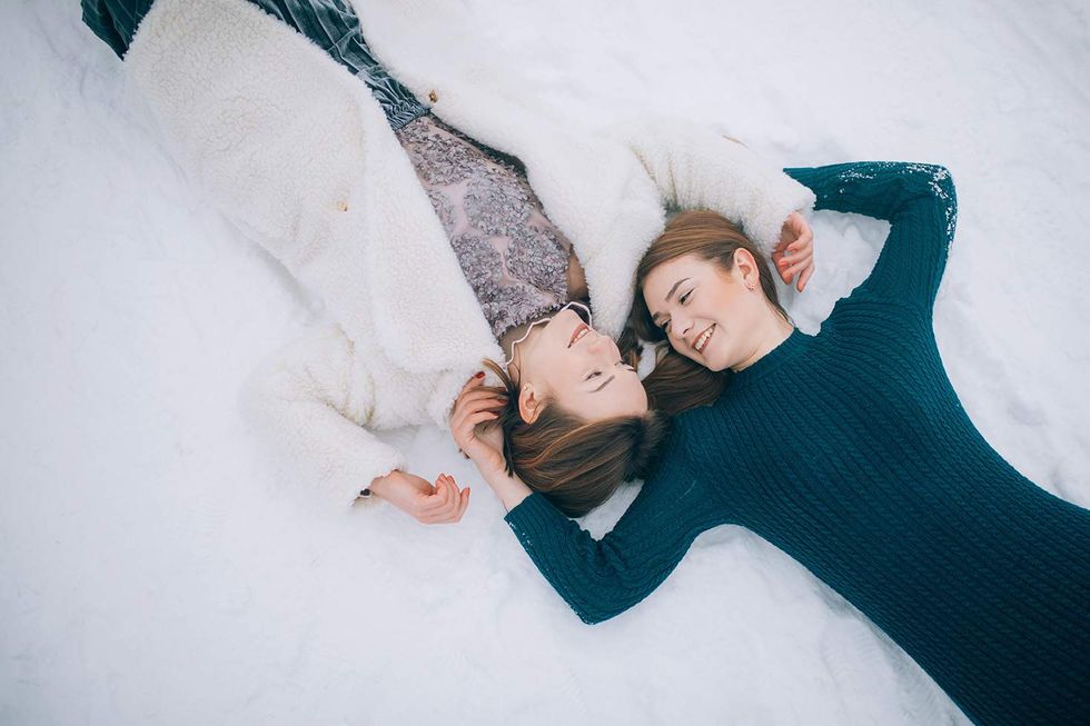 two women lying in the snow