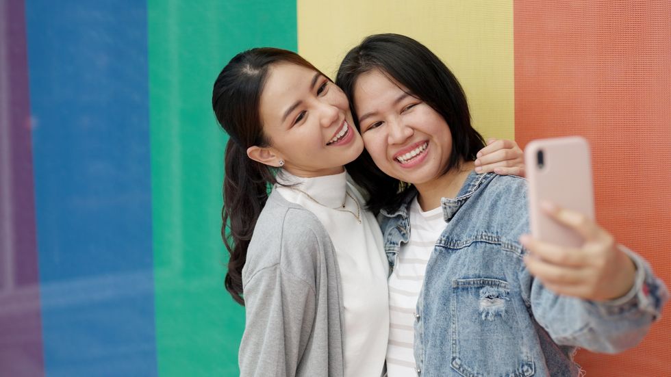 two women smiling to a phone camera