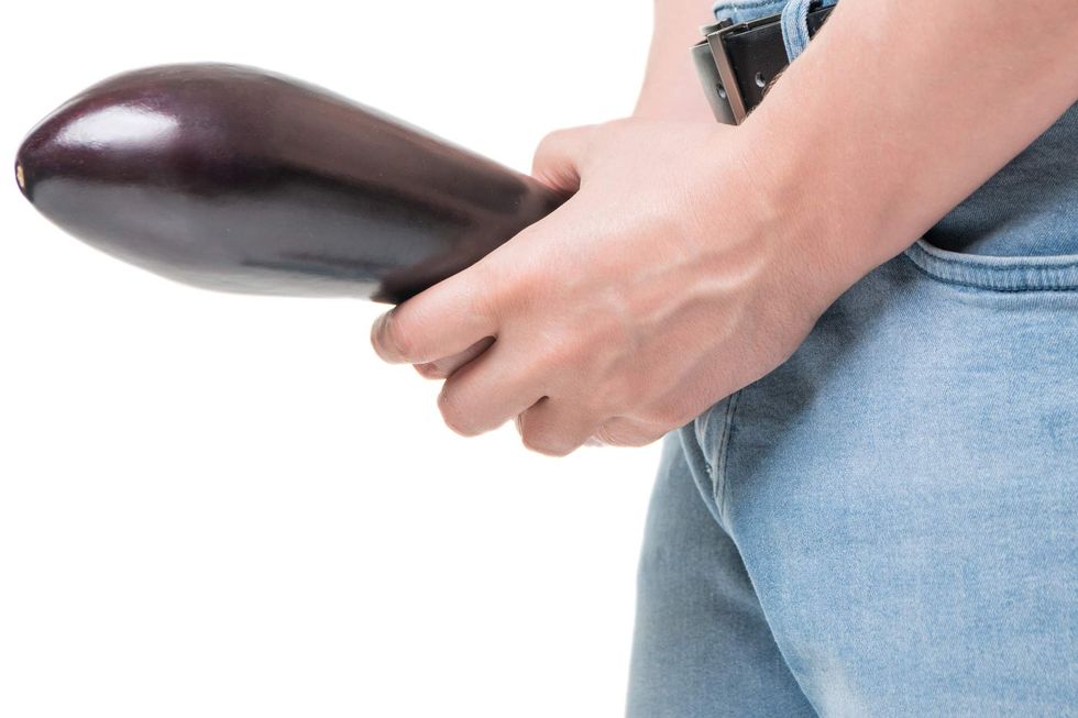 \u200bA man holding an eggplant.