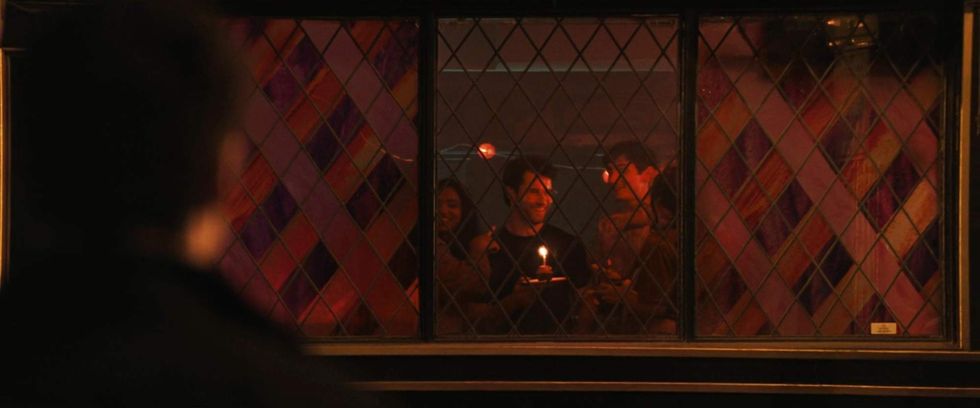 \u200bScott watching Kip celebrate his birthday in 'Heated Rivalry' episode 3.