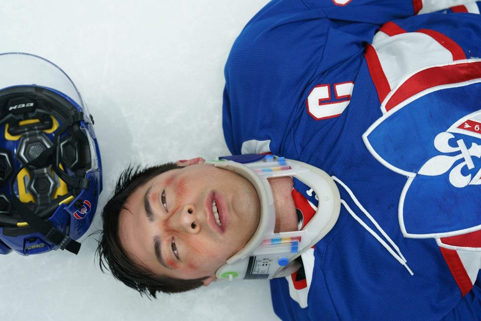 \u200bShane Hollander lying on the ice with a neck brace in 'Heated Rivalry' episode 5.