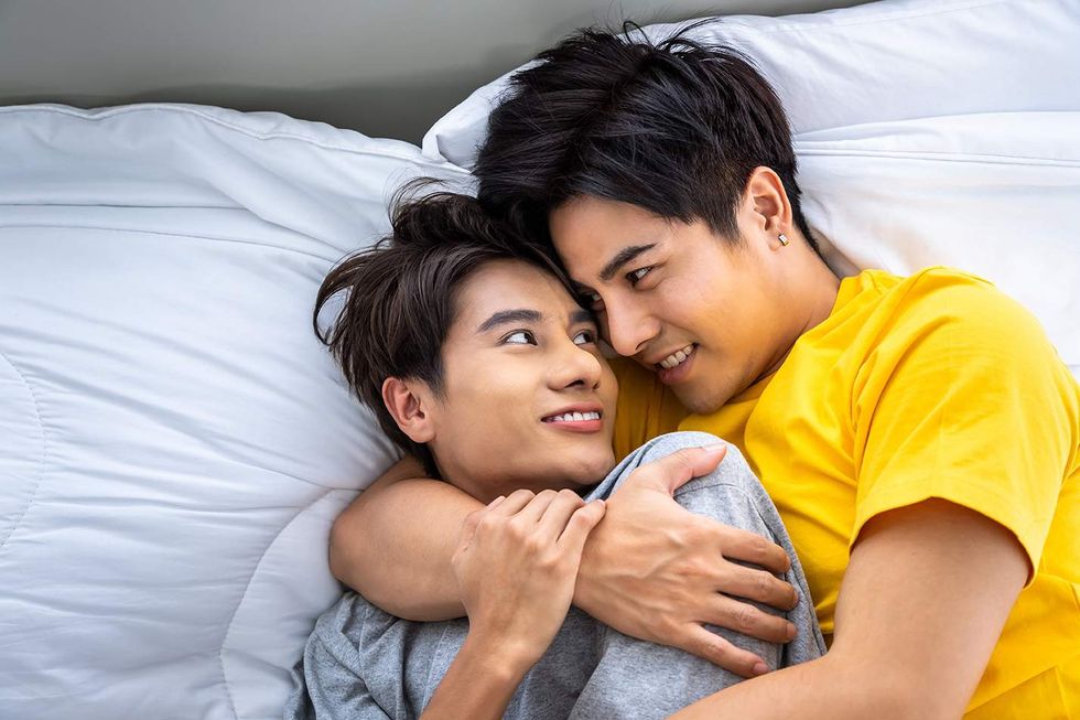 \u200bTwo gay men cuddling in bed.