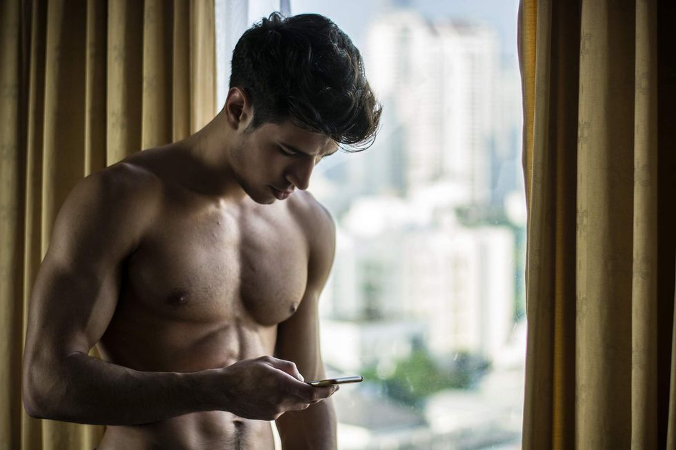 \u200bYoung man holding a cell phone.