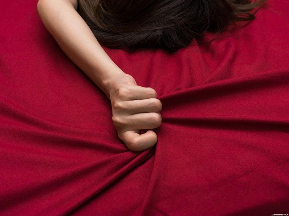 woman clutching a bed sheet