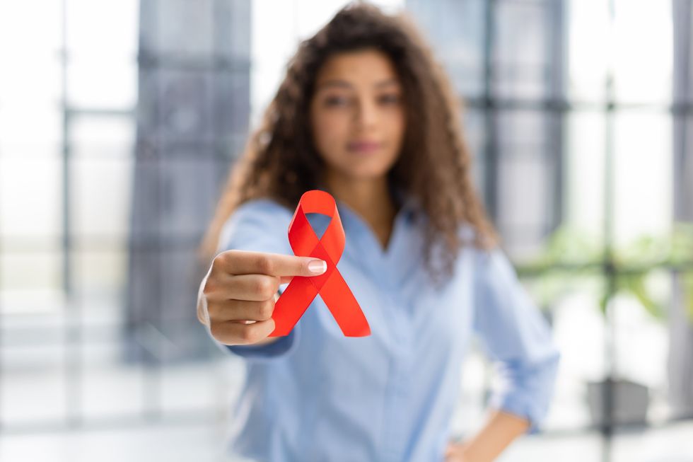 woman holding hiv red ribbon