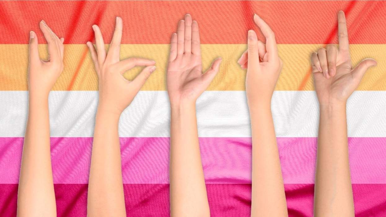 women's hands over a lesbian flag