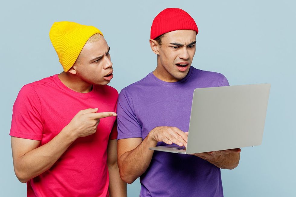 Young confused shocked sad disgusted couple two friend IT men wear casual clothes together hold use work point on laptop pc computer isolated on pastel plain light blue cyan background studio portrait